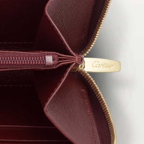 Must de Cartier Brieftasche mit Reißverschluss, internationales Format Bordeauxrotes Kalbsleder, Gold-Finish